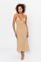 Artemisia Dress: sleeveless sand dress with square neckline, fitted waist, straight midi hem