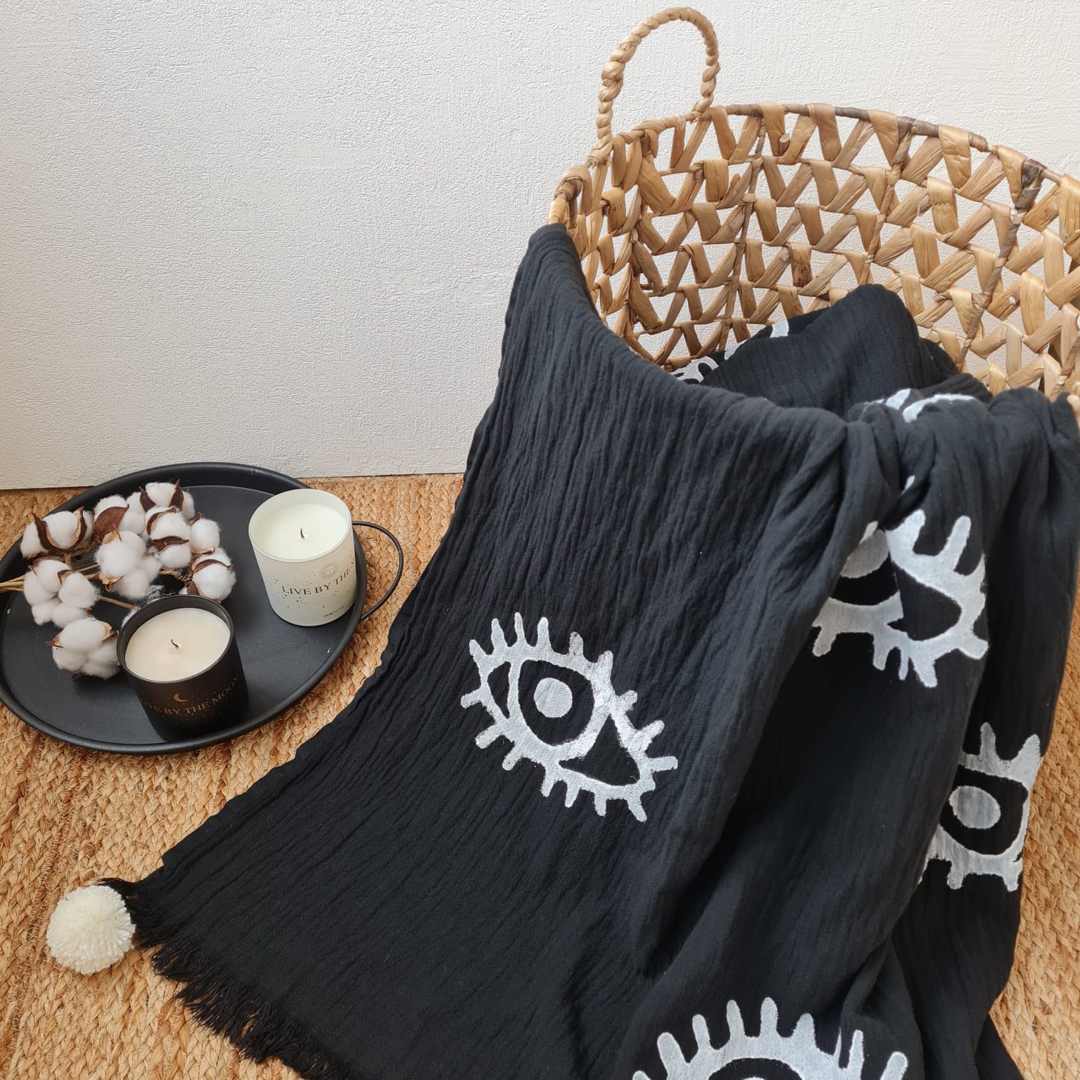 Black evil eye blanket: rectangular black blanket with central blue and white eye motif and fringed edges