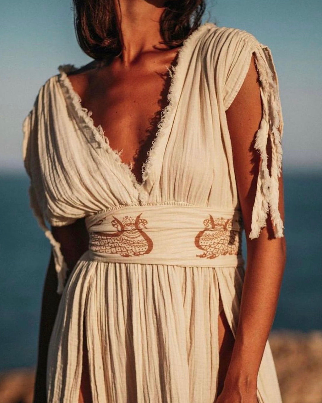 Shahmaran Dress: sleeveless, straight fit midi dress with high neckline and chest cutouts in beige