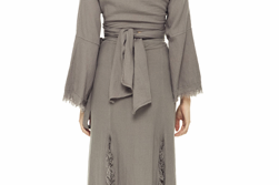 Back view of maxi wrap skirt with wide self-tie belt, bell sleeves top, raw fringe trim along slit and hem