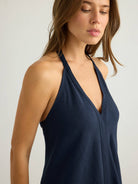 Deep navy halter V-neck bodice, close-up front view showing clean center seam, thin halter ties at neck, relaxed slub fabric drape on woman with loose brunette hair.
