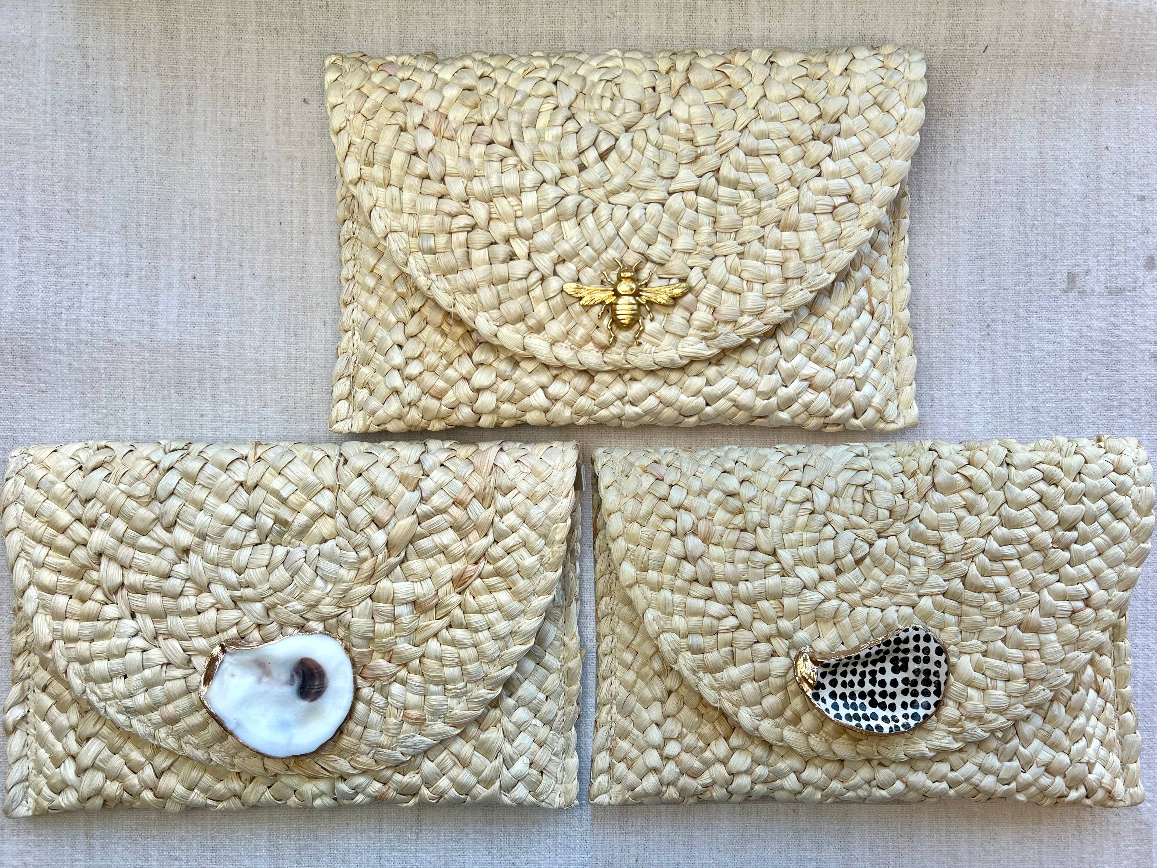 Straw clutch handbag: rectangular shape, beige color, fold-over flap, woven texture, no handle visible