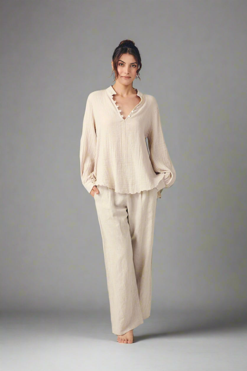 Cuneyd Blouse: loose fit, ivory color, V-neckline, long bishop sleeves, gathered cuffs, curved hem