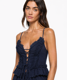 Navy corset top with frayed cotton trim along deep V neckline, lace-up front tie detail, and thin spaghetti straps. Close cro
