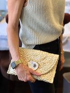 Straw clutch handbag: rectangular shape with natural straw texture and fold-over flap closure